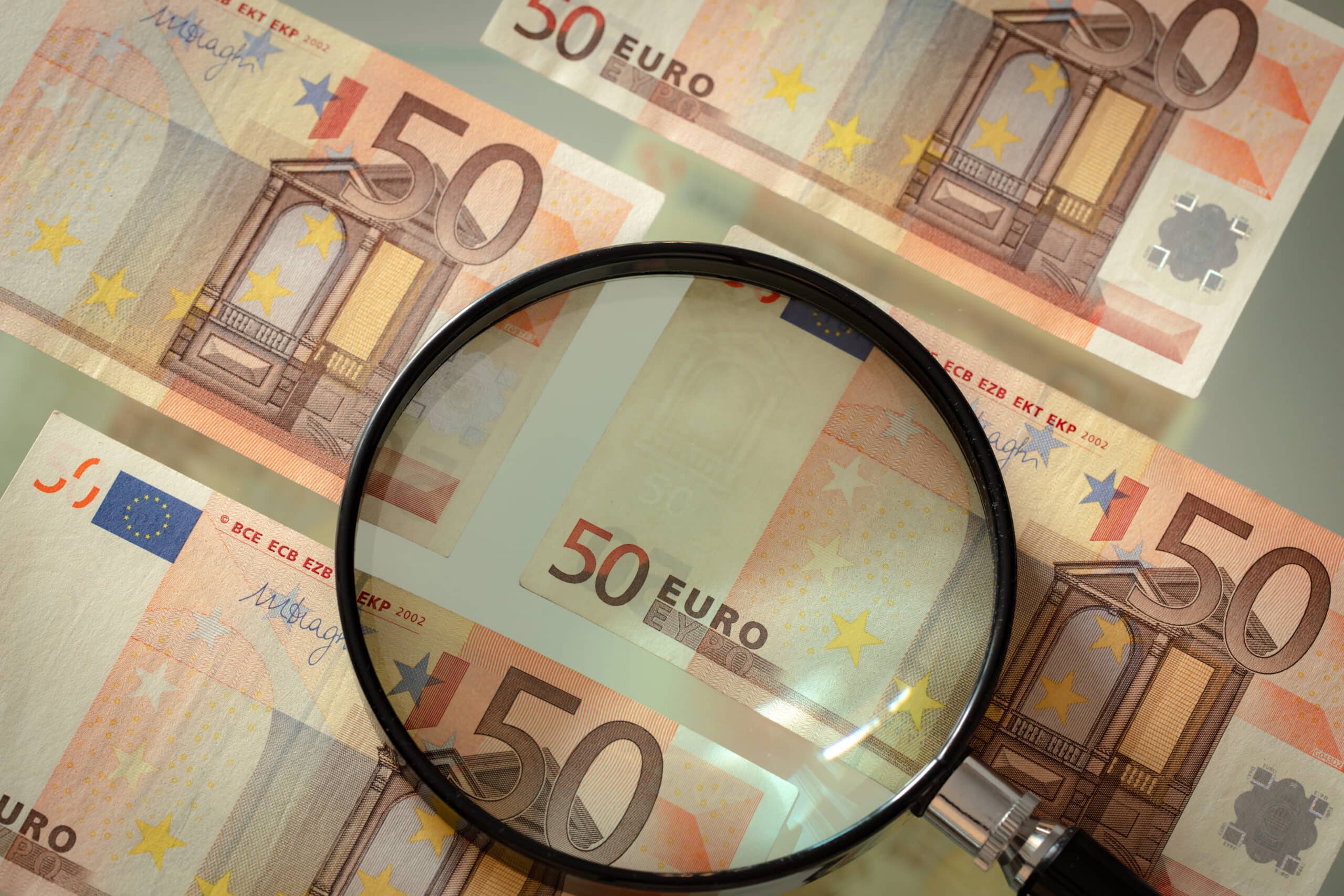 Esame banconota da 50 euro con lente d'ingrandimento